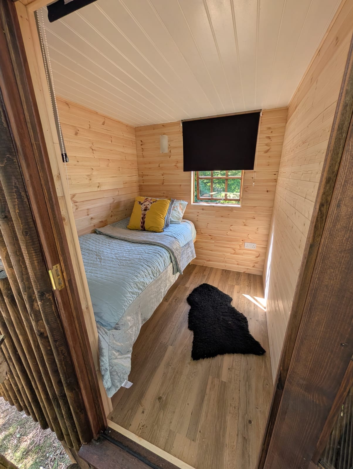 Timber-clad treehouse interior with fitted bedroom by Cover It Building